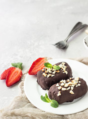Glazed cheese curds with chocolate, peanut, strawberry and mint on a white plate. Sweet breakfast or dessert. High key.