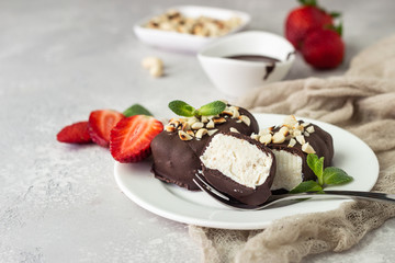 Glazed cheese curds with chocolate, peanut, strawberry and mint on a white plate. Sweet breakfast or dessert. High key.