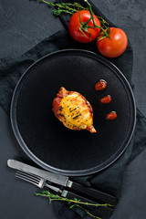 Stuffed squid in tomato sauce. Black background, top view