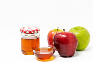Rosh Hashanah (Jewish New Year) Traditional Symbols, Honey in a glass jar, Red And Green Apples. Isolated On A White Background
