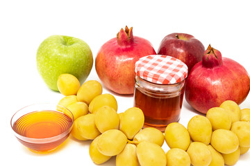 Rosh Hashanah (Jewish New Year) Traditional Symbols, Honey in a glass jar, Pomegranates, Dates, Red And Green Apples. Isolated On A White Background
