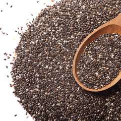 Raw Chia seeds in wooden spoon closeup on white background