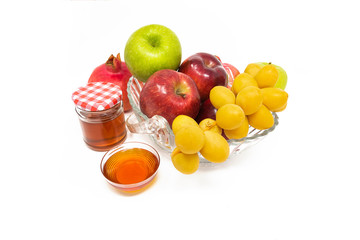 Rosh Hashanah (Jewish New Year) Traditional Symbols, Honey in a glass jar, Pomegranates, Dates, Red And Green Apples. Isolated On A White Background	