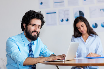 Laughing indian businessman and businesswoman at work