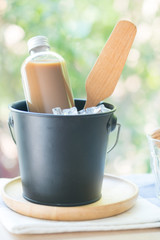 Coffee bottle design mockup served ice black bucket at coffee shop.