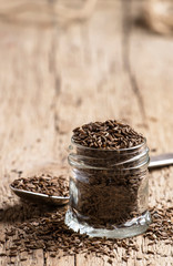 Caraway grain in the jar, vintage wooden background, selective focus