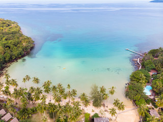 Tropical beach aerial view from drone with blue transparent sea water and coconut palm trees, seaside tourist hotel resort with beautiful landscape for summer vacation holidays