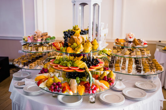 Exotic, organic fruits, light snacks in a plate on a buffet table. Assorted mini delicacies and snacks. Decorated delicious table for a party goodies