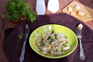 Roasted Jerusalem artichoke with cheese and parsley on a green plate. Healthy food