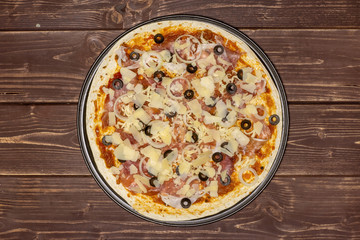 Ready to oven step. recipe step by step pizza capricciosa flatlay on brown wood
