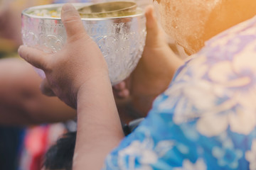 People are holding a bowl of water perfume with flower preparing to shower for the monks on Songkran day.(Thailand New Year)