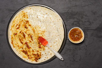 Put passata with a brush. recipe step by step pizza capricciosa flatlay on grey stone