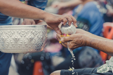 Thai people celebrate Songkran by pouring water and giving garlands to elder senior or respected grandparents and elder and asked for blessings for celebrate Songkran in new year water festival