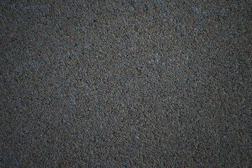 Concrete texture with blurred edges. Horizontal background of dark gray concrete floor with many small stones.