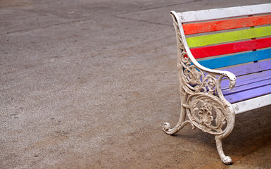 Closeup of a metallic chair with colored wooden planks in outdoors