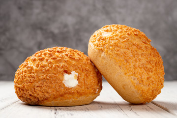 two pieces sweet puffs on a white wood table