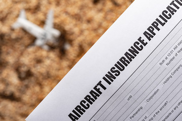 aircraft insurance application wtih a blurred crashed aircraft model on back