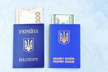 Internal passport of Ukraine with the national currency hryvnia inside and biometric document for international travel with dollar. Passport of a citizen of Ukraine and id passport with money inside 