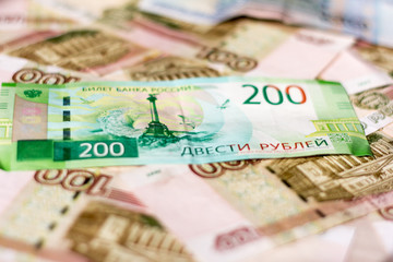 money background, Russian hundred-ruble and two-ruble bills in a mess lying on the table.