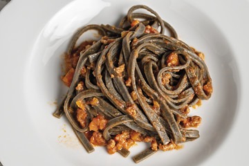 pasta al nero di seppia fettuccine al ragù primo piano dall'alto