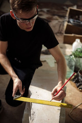 A man measures the distance with a square