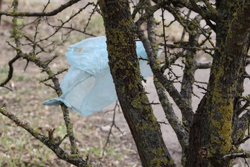 Garbage in the forest. Plastic bags thrown in the forest grass and bushes. The problem of ecology...