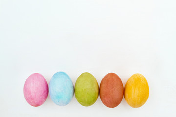 Flat lay of colorful Easter eggs on white background. High angle view.