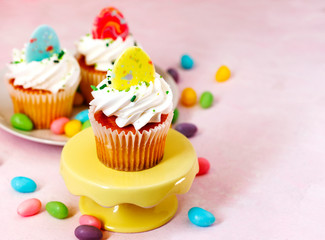 Easter vanilla cupcakes on pink background, copy space