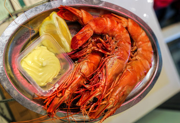 Jumbo shrimps with lemon and sauce on metal plate