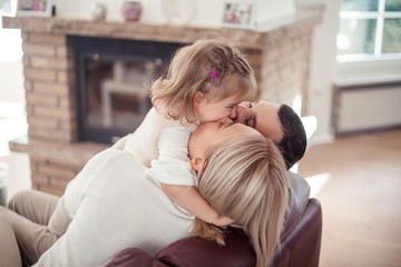 Emotional family portrait by burning fireplace in cozy home