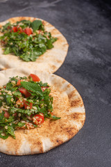 Tabbouleh salad, traditional middle eastern or arab dish, on pita bread. Usually prepared with parsley, mint, bulgur, tomato
