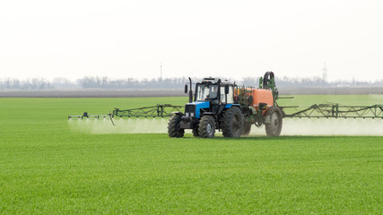 Tractor with a spray device for finely dispersed fertilizer.
