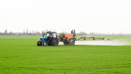 Tractor with a spray device for finely dispersed fertilizer.