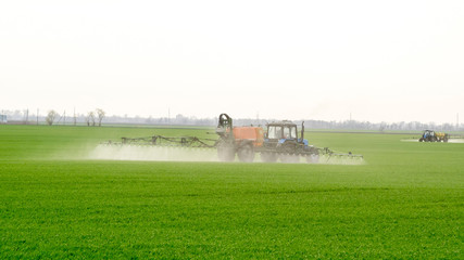 Fototapeta premium Tractor with a spray device for finely dispersed fertilizer.