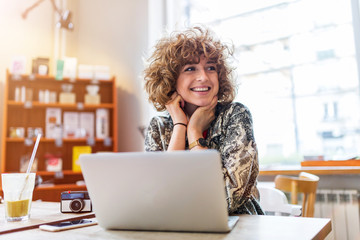 Young woman working on her laptop in cafe
