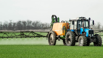 Tractor with a spray device for finely dispersed fertilizer.