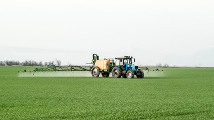 Tractor with a spray device for finely dispersed fertilizer.