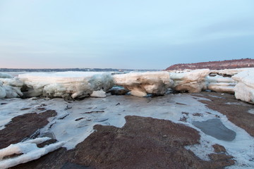 Late winter blue hour morning view of large ice chunks melting on the rocky banks of the St. Lawrence river in the Cap-Rouge area of Quebec City, Quebec, Canada