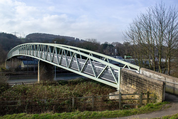 An elegant footbridge swoops across both road and railway