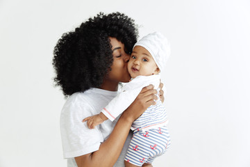 Closeup portrait of beautiful african woman holding on hands her little daughter on white background. Family, love, lifestyle, motherhood and tender moments concepts. Mother's day concept or