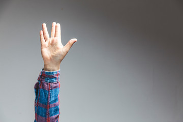 male adult hand showing prosperity wish gesture in studio shot isolated on grey background