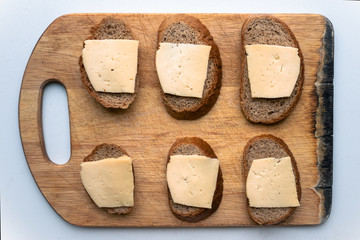 six cheese sandwiches. poor sandwich. ascetic food. healthy food. not skillful cooking. loaf of bread with a piece of cheese top view