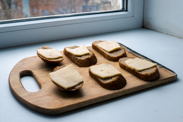 six cheese sandwiches. poor sandwich. ascetic food. healthy food. not skillful cooking. loaf of bread with a piece of cheese closeup