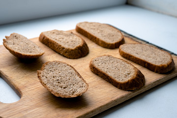 Six beautiful sliced pieces of bread on a wooden board on a white background. malt bread