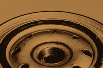 Monochrome background image of oil filter close up. Art macro photography of auto part in sepia tones.