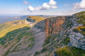 A large panorama of the Bermamyt plateau on a summer day. Hills and clouds in the distance.