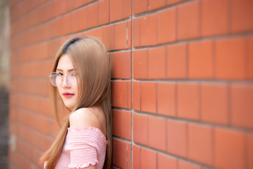 Fototapeta premium Portrait of beautiful asian chic girl wear black dress pose for take a picture on brick wall,Lifestyle of teen thailand people,Modern woman happy concept,Korea style