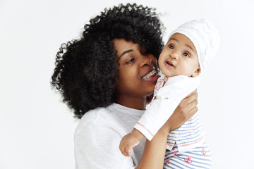 Closeup portrait of beautiful african woman holding on hands her little daughter on white background. Family, love, lifestyle, motherhood and tender moments concepts. Mother's day concept or