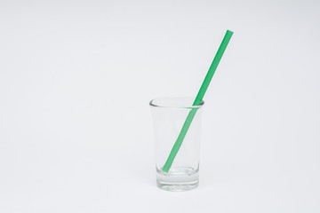empty glass with GREEN straws on a white background