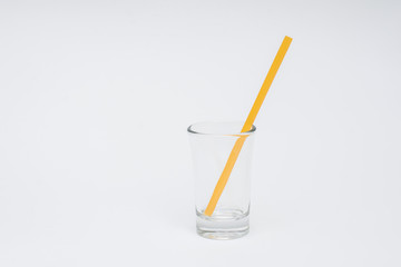 empty glass with yellow straws on a white background